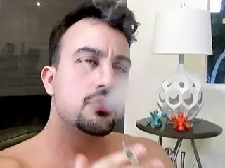 Gay guy relaxes while smoking and strokes his big schlong